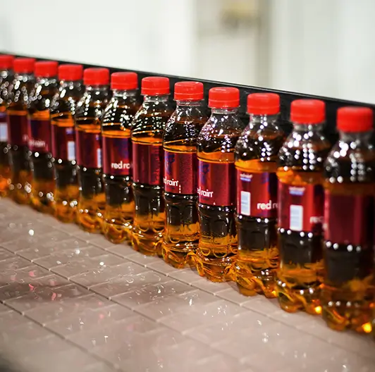 Lineup of Red Rain bottles with red caps on display table